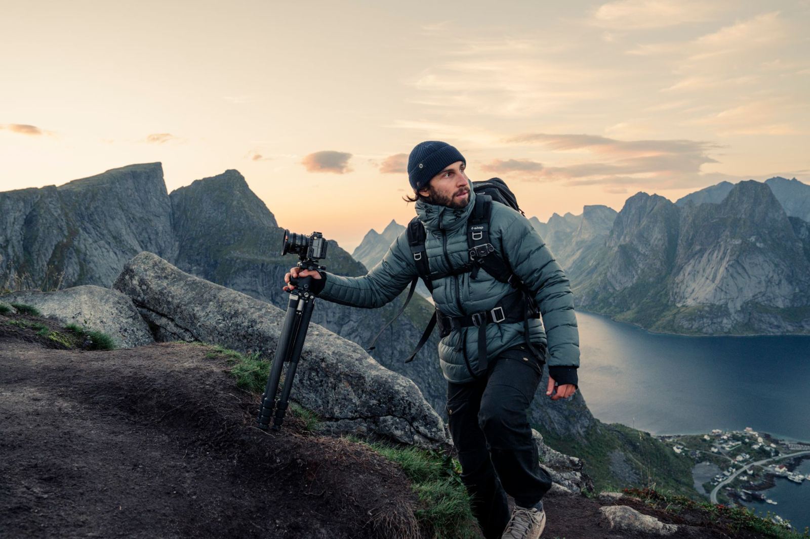 Ricardo hiking with a tripod above a fjord